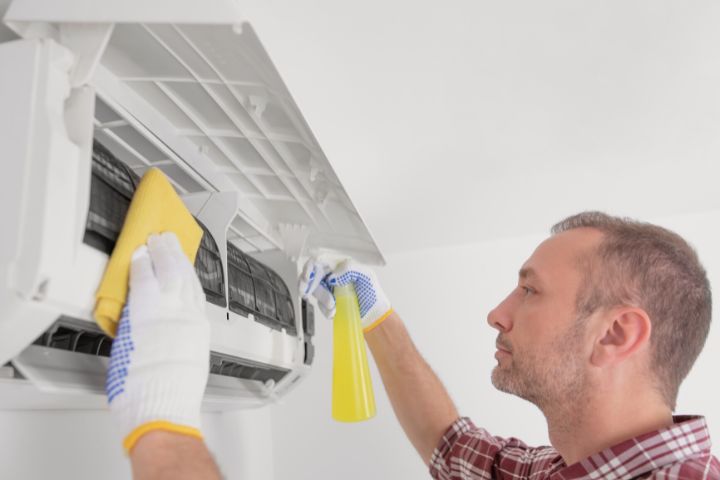 Service Guy Cleaning and Maintaining Air Condition Unit